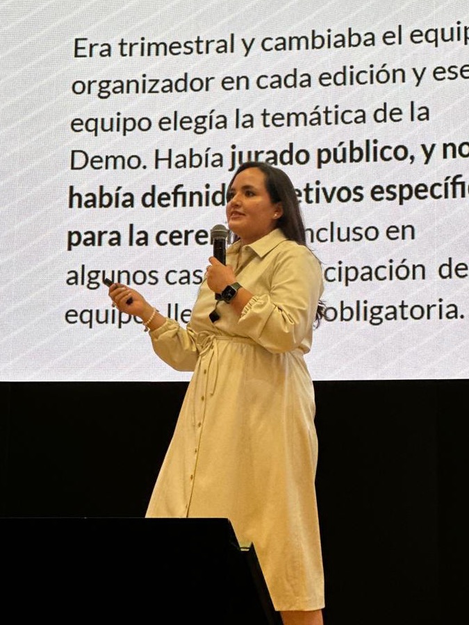 Fabiola Ledesma dando una conferencia en un escenario, con micrófono